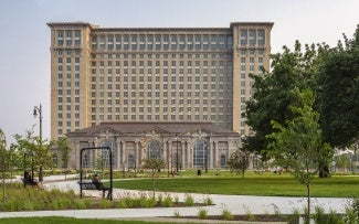 exterior of Michigan Central Station at day; tree in foreground