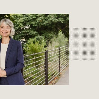Kaarin Knudson, AIA, smiling in a park with trees and greenery.