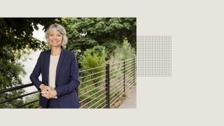 Kaarin Knudson, AIA, smiling in a park with trees and greenery.