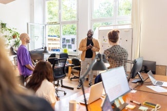 group of team members discussing statistics in light-filled room
