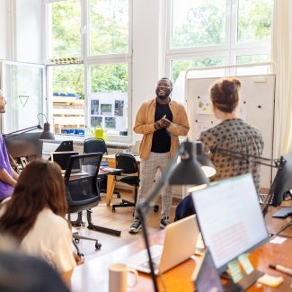 group of team members discussing statistics in light-filled room