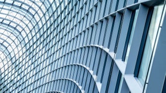 Close up of curved metal and glass building