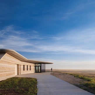 Camouflaging into the context, the building's form emulates its surroundings. Four varieties of local limestone wrap the exterior in stratified bands, emulating the layers of stone peaking from the surrounding hillsides.